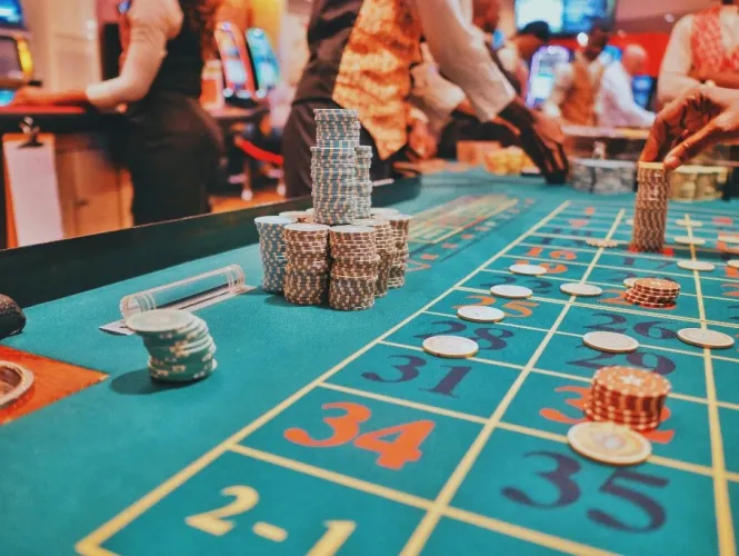 Une table de casino, recouverte de jetons, entourrée de joueureuses