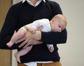 Bébé porté par son papa sur l'avant bras