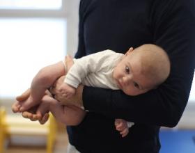 Bébé porté par son papa sur l'avant bras
