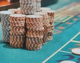 Une table de casino, recouverte de jetons, entourrée de joueureuses
